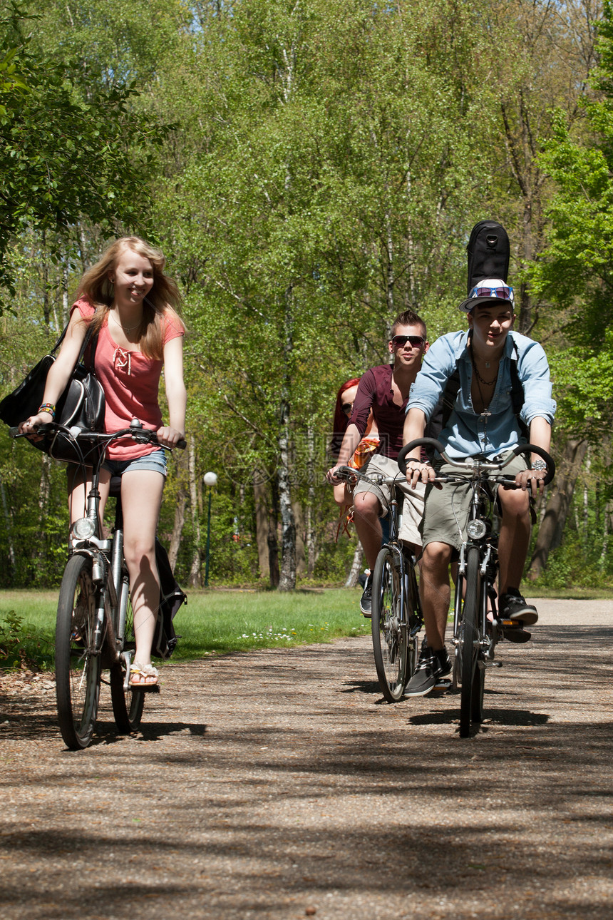 骑自行车的青少年快乐树木青年微笑童年友谊学生朋友们团体森林图片