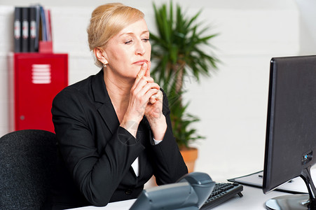 调查计算机屏幕的公司女公司主女士键盘女性冒充人士桌子经理老板中年思想家思维背景图片