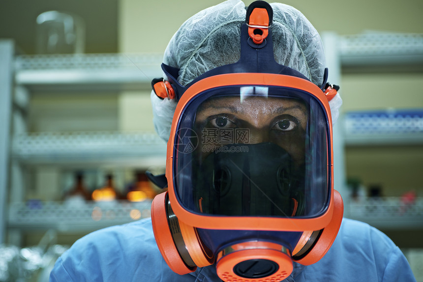 穿着防毒面具在科学实验室工作的妇女的肖像图片