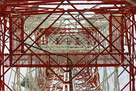 格子塔通讯塔 有美丽的蓝色天空 集成蓝天工程电视技术基础设施格子梯子收音机金属红色背景