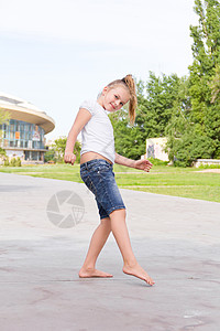 可爱的女孩跳着一条腿跳白色女学生蓝色童年孩子舞蹈金发背景图片