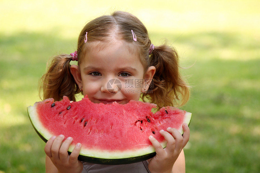 美丽的小女孩吃西瓜女性公园女儿红色食物童年白色孩子绿色青年图片