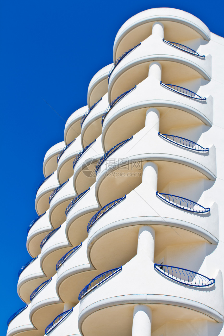 结盘蓝色建筑房子公寓晴天石头酒店栏杆旅游天空图片