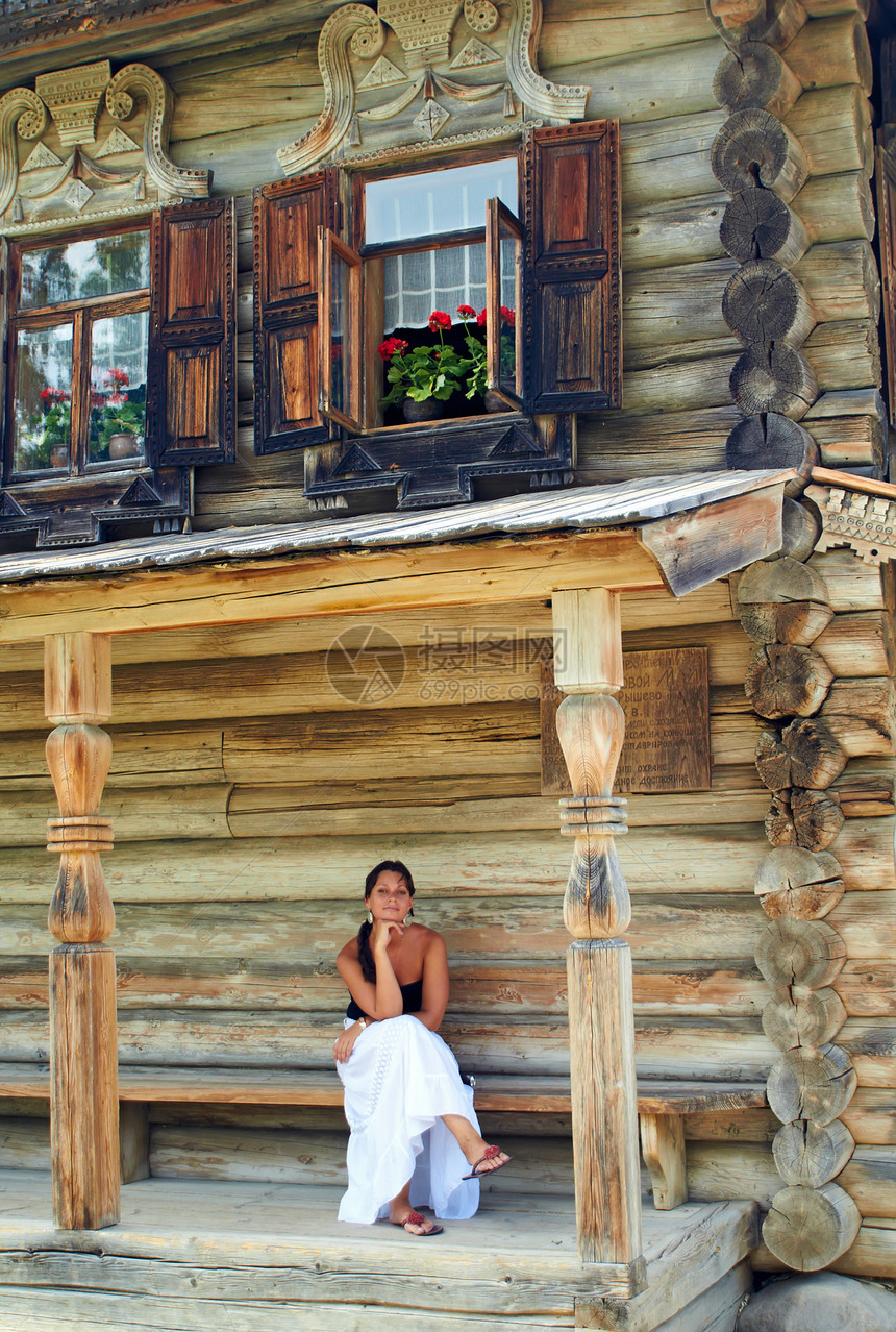 在旧俄罗斯木屋前的年轻女人 女青年图片