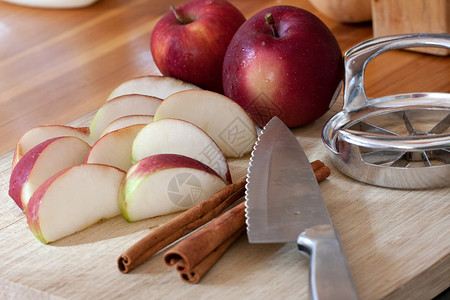 苹果分割去核器切苹果和肉桂棒背景