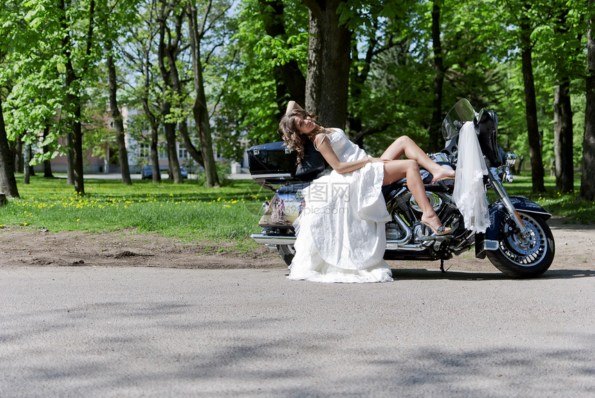 坐在摩托车上的美丽年轻新娘女孩女士白色自行车庆典妻子裙子图片