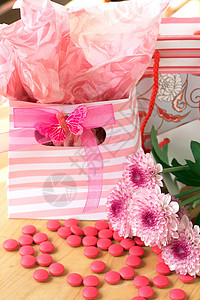 两袋带粉红色糖果的礼物袋展示生日派对包装蝴蝶惊喜庆典粉色纸盒背景图片