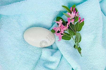 蓝毛巾上的肥皂背景图片