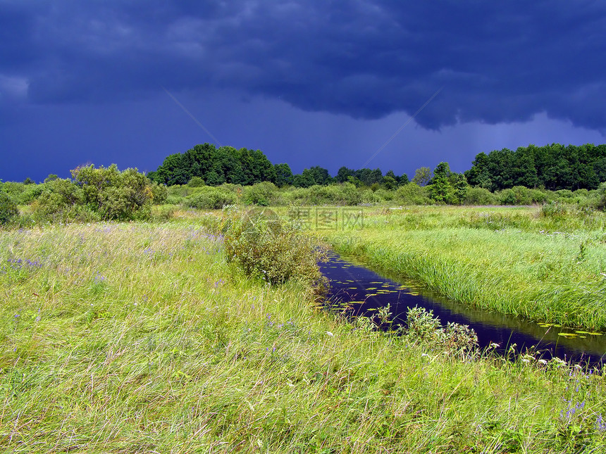 暴风雨前田地上的小河图片