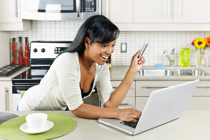 妇女在家里网上购物笔记本微笑厨房技术网络支付购物房子电脑少数民族图片