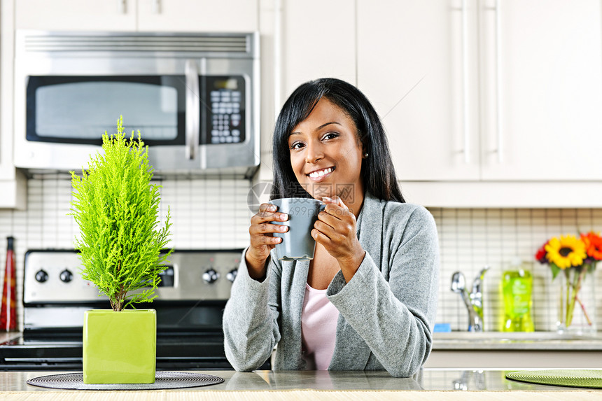 厨房里有咖啡杯的女人杯子内饰咖啡女性微笑幸福奢华台面房子柜台图片