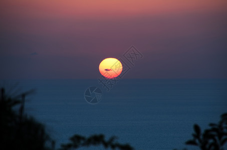 日落在海面上太阳天空蓝色红色背景图片