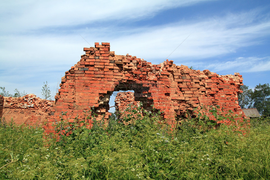 药草间被摧毁的砖墙修理拆除红色材料废墟岩石建筑学石头灰尘棕色图片