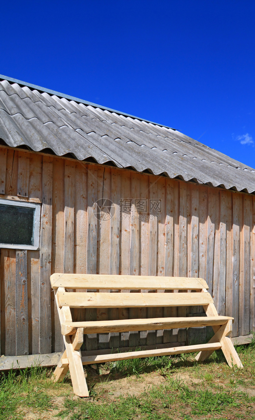 木墙附近的木板凳白色木头长椅谷仓植物休息椅子公园图片