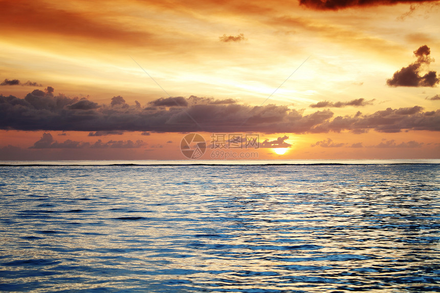 日落在海中太阳橙子地平线海滩阳光海浪海岸线天气海洋场景图片