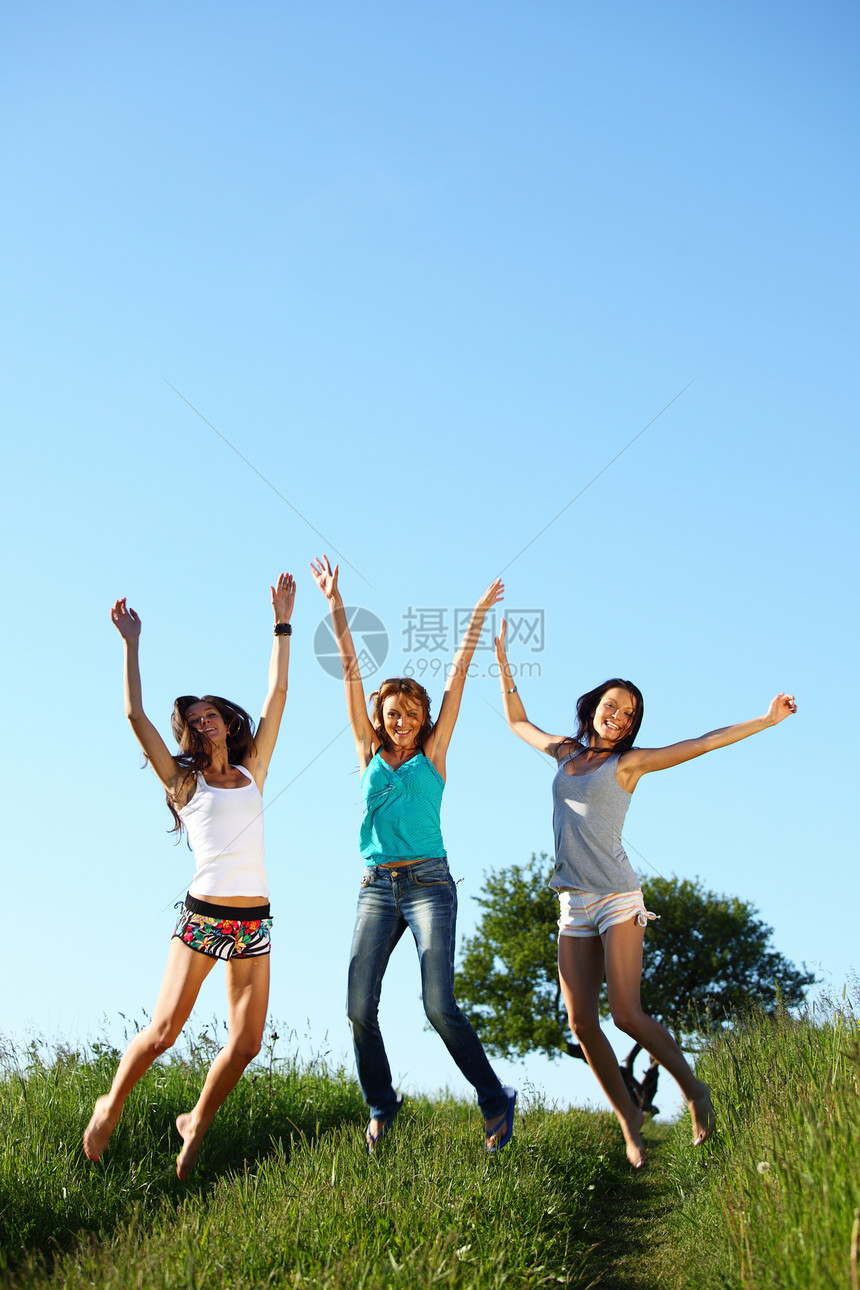 女友跳跃活力头发自由太阳行动草地乐趣空气成人活动图片