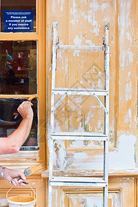 油漆绘画零售商梯子工作窗格工人装潢师橙子装潢店铺黄色背景图片