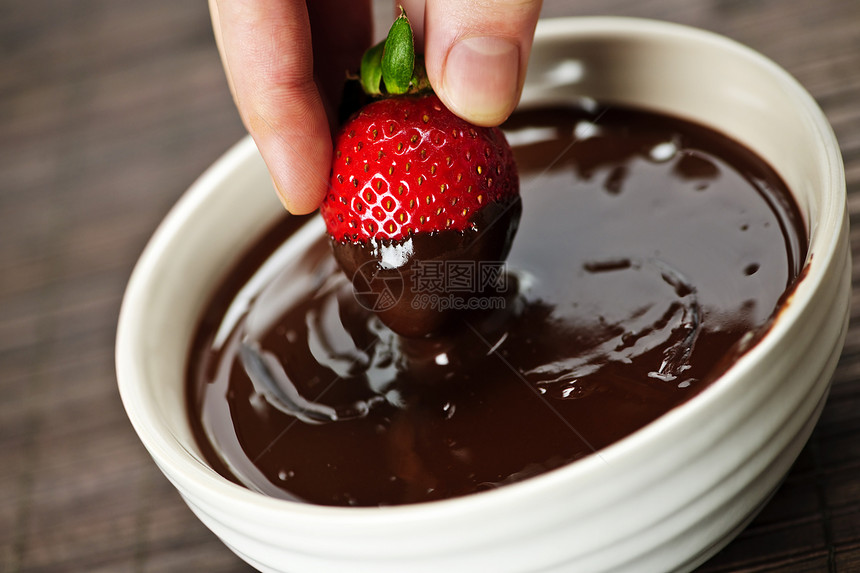 手把草莓撒在巧克力里小吃食物甜点水果可可浆果糖果涂层液体美食图片