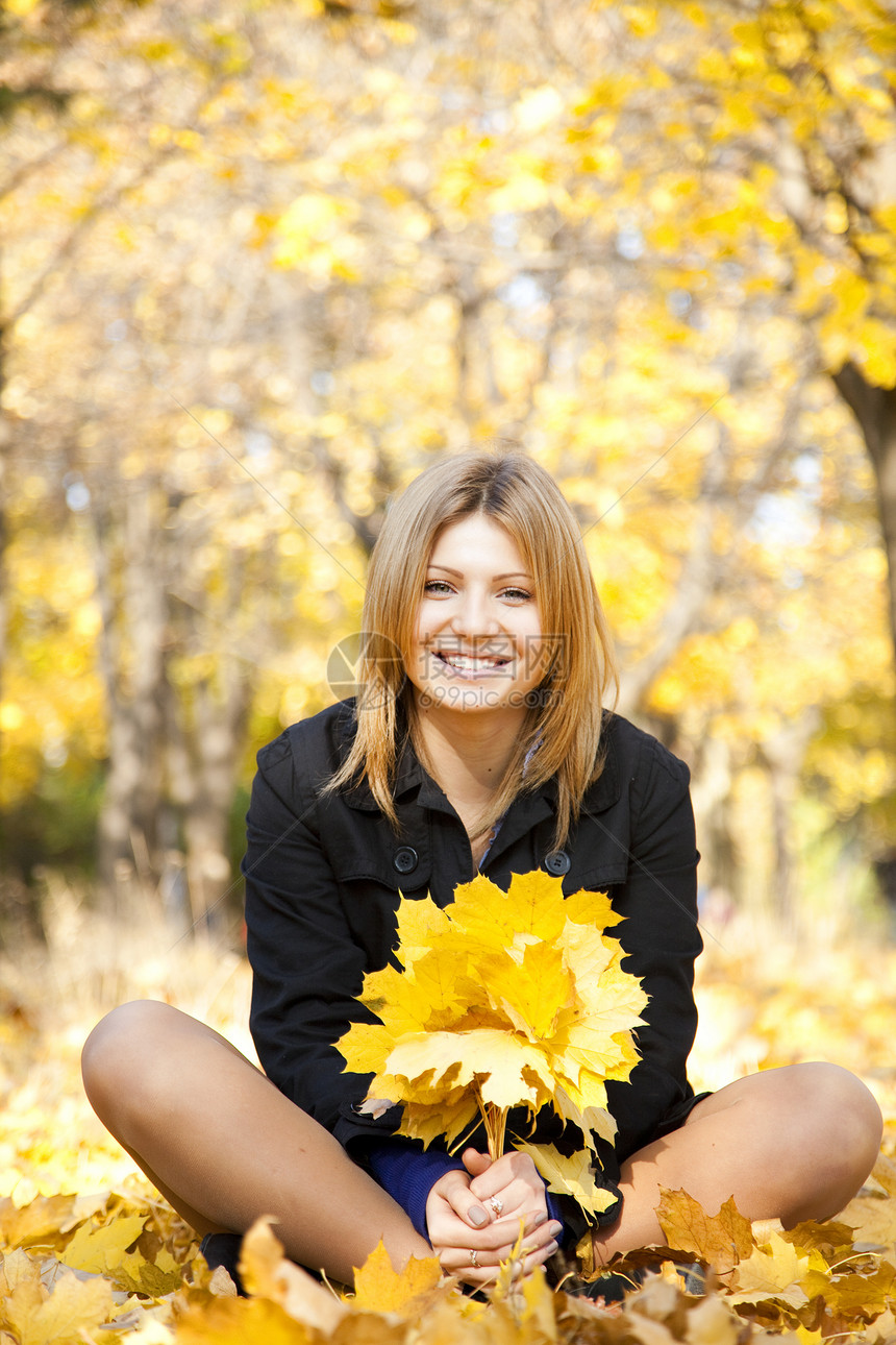 在秋天公园微笑的快乐女孩头发叶子感恩季节公园后代毛衣橙子女士少年图片
