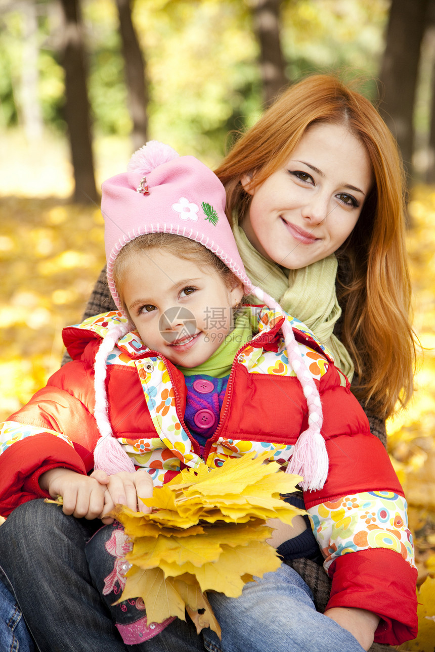 秋天黄色公园的母亲和女儿孩子金发童年女孩叶子家庭长发感恩橙子小姑娘图片