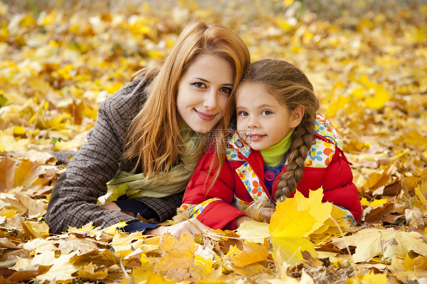 秋天黄色公园的母亲和女儿后代童年家庭女孩妈妈金发感恩季节夹克小姑娘图片