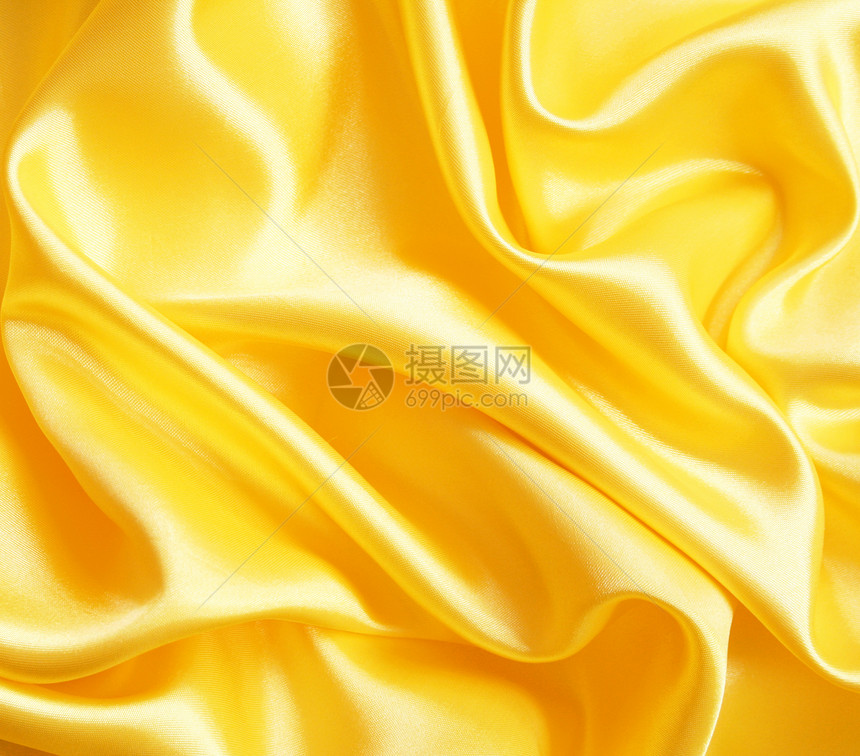 平滑优雅的金色丝绸作为背景织物曲线材料布料纺织品投标折痕涟漪海浪黄色图片