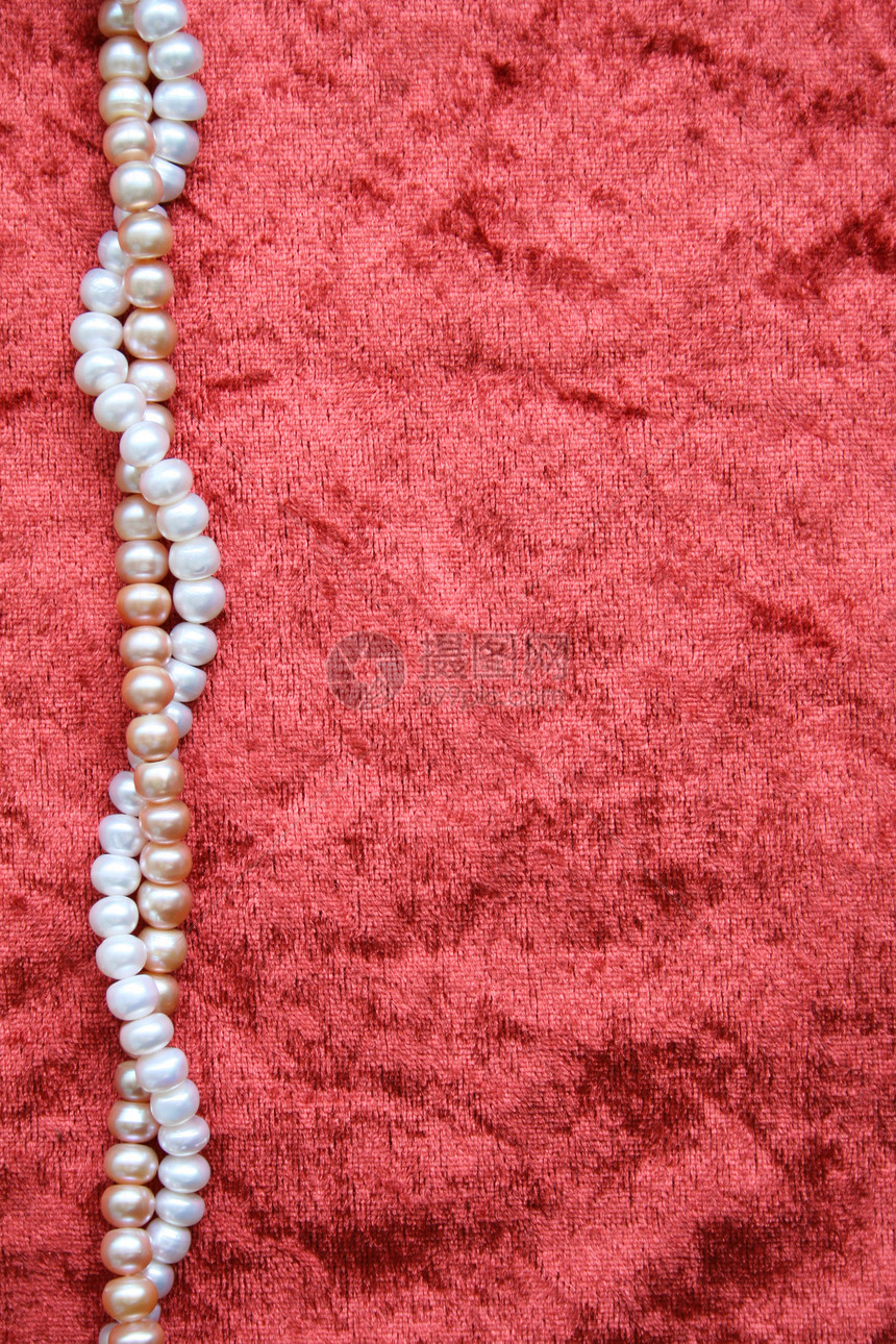 天鹅绒背景上的白珍珠和粉红珍珠图片