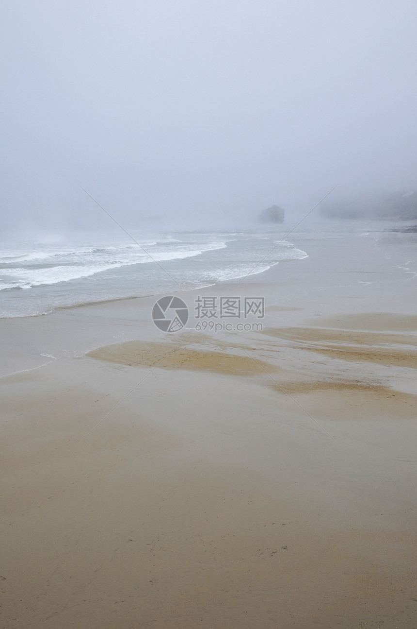 在雨下的海滩下 与微雾的天气图片