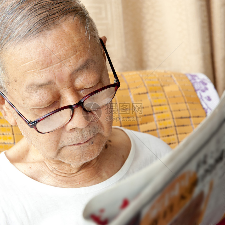 一名年长者正在阅读报纸头发男性乐趣居住祖父灰色摄影享受脸颊快乐图片