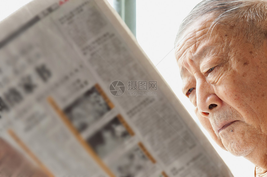 一名年长者正在阅读报纸摄影灰色脸颊祖父快乐居住男性生活享受男人图片