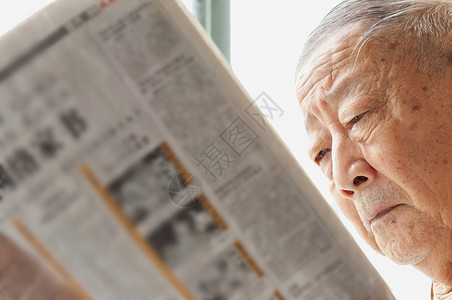 一名年长者正在阅读报纸摄影灰色脸颊祖父快乐居住男性生活享受男人背景图片