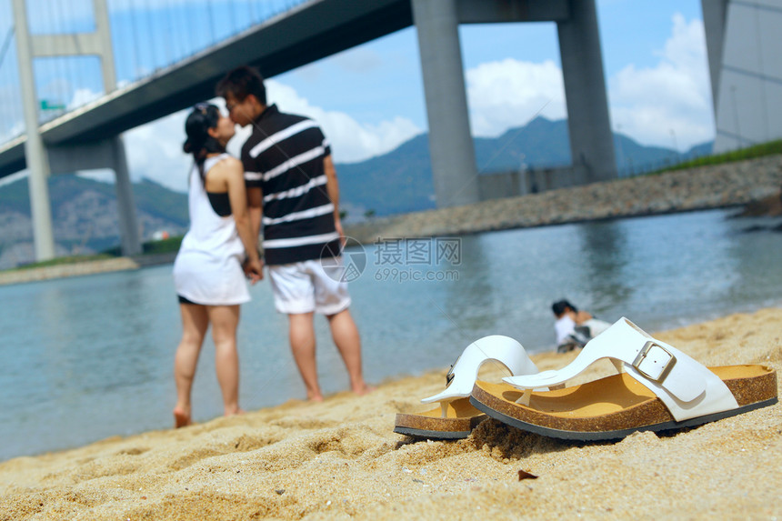 现代夫妻在海滩上亲吻对方图片