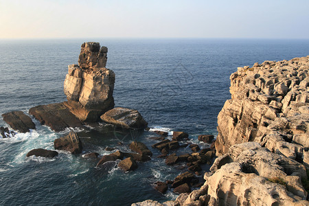 海洋中的岩石海浪天空背景图片