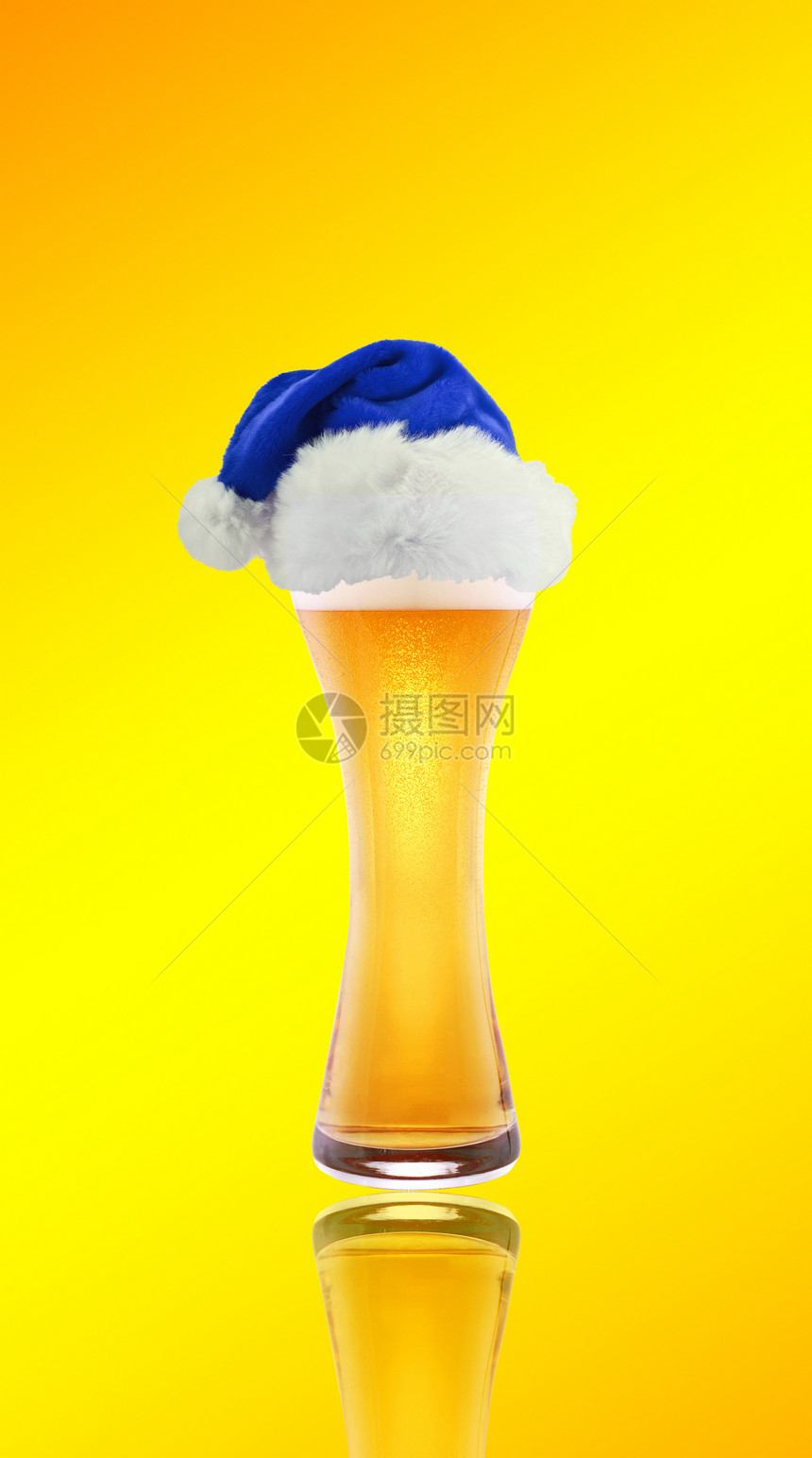 啤酒和圣诞老人的帽子 在黄色背景上图片
