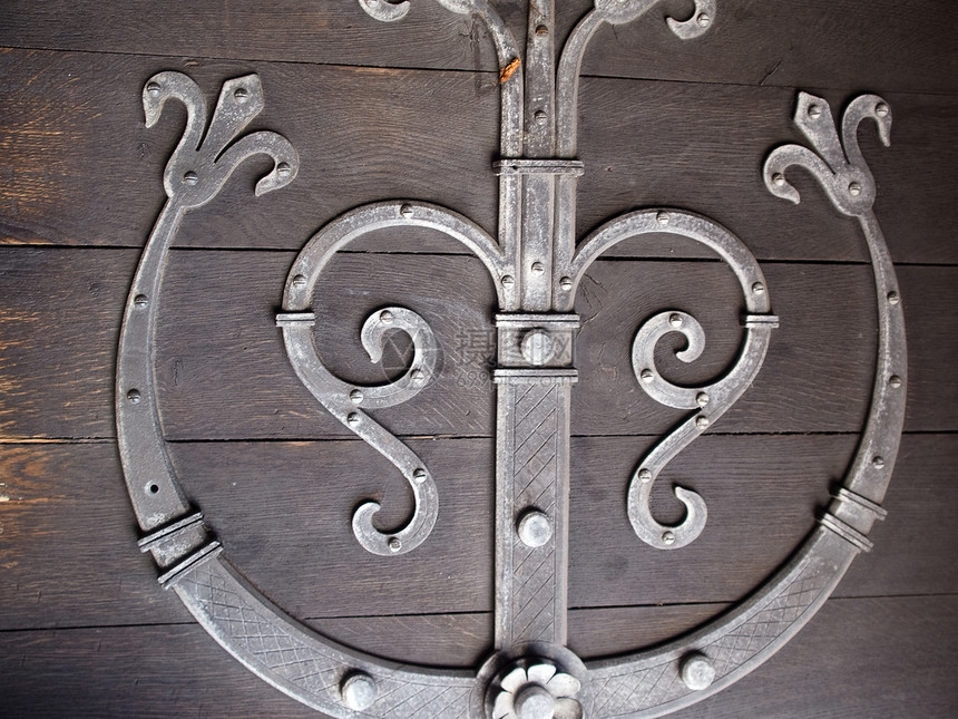 一扇装有金属装饰的旧木门的详情图片