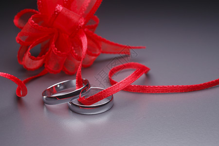 银色结婚戒指丝带订婚首饰红色婚礼背景图片