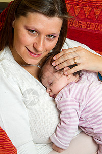 母亲拥抱婴儿入睡父母孩子甜蜜尿布家庭微笑粉色背景图片