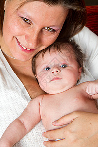 育有婴儿的母亲家庭拥抱尿布孩子父母甜蜜粉色微笑背景图片