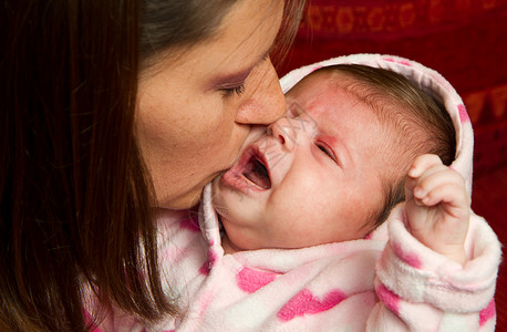 母亲亲吻婴儿粉色甜蜜情绪父母家庭眼泪孩子背景图片