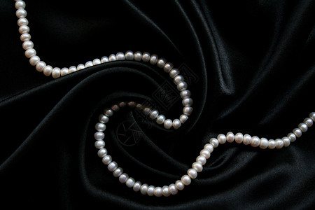 黑丝上的白珍珠项链展示魅力珠宝宝石宝藏细绳珍珠珠子天鹅绒背景图片
