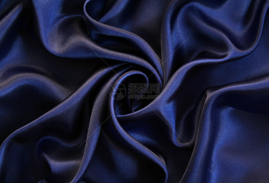 平滑优雅的深蓝丝绸作为背景丝绸纺织品织物海浪银色曲线材料折痕投标布料图片