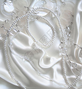 白珍珠和小蜜蜂 在白色丝绸上 作为婚礼的回礼手镯女性化珠子魅力珍珠象牙珠宝细绳奢华礼物背景