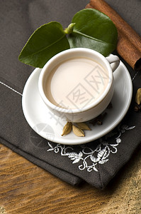 马萨拉沙伊茶杯牛奶小豆蔻礼仪树叶肉桂香料粉红色泡茶时间背景图片