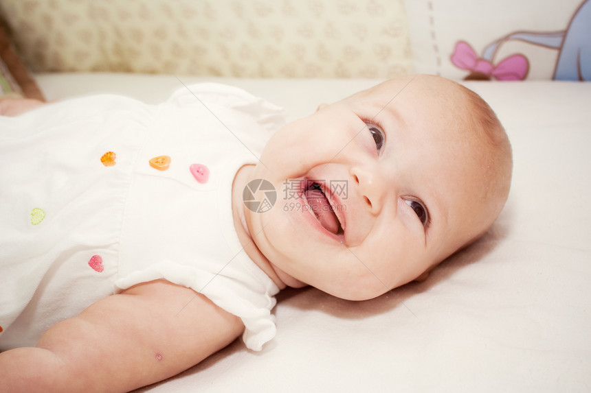 小女孩在床上的肖像乐趣手指生活白色幸福婴儿蓝色皮肤玩具童年图片