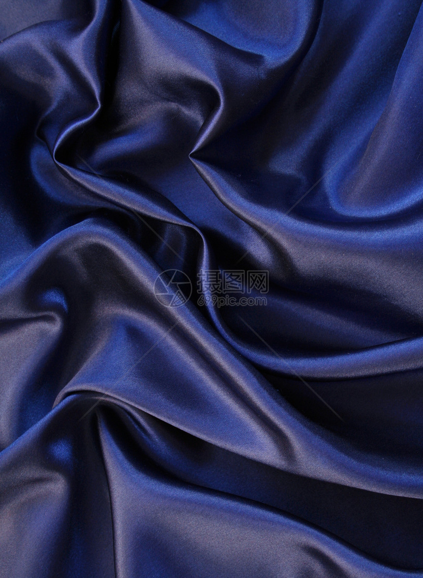 平滑优雅的深蓝丝绸作为背景布料丝绸海浪织物折痕纺织品银色蓝色材料曲线图片
