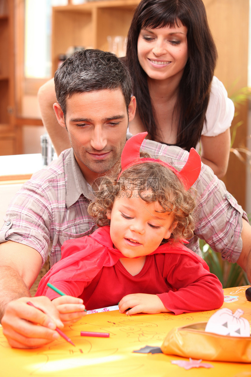 一个小女孩和父母的肖像孩子女孩桌子幸福铅笔喜悦童年派对家庭卷曲图片