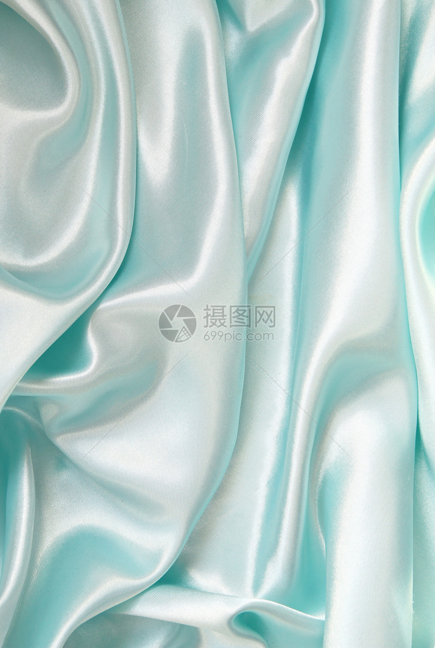 平滑优雅的蓝色丝绸可用作背景布料曲线材料海浪银色织物纺织品投标折痕图片