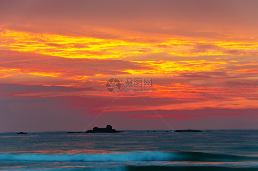 日落时的海滨海洋孤独风景海景边缘橙子太阳自由岩石海浪图片