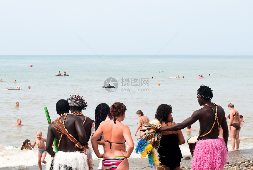 人们在海岸有休息时间日光浴男人旅游沙滩波浪旅行者太阳女人沙地大海图片