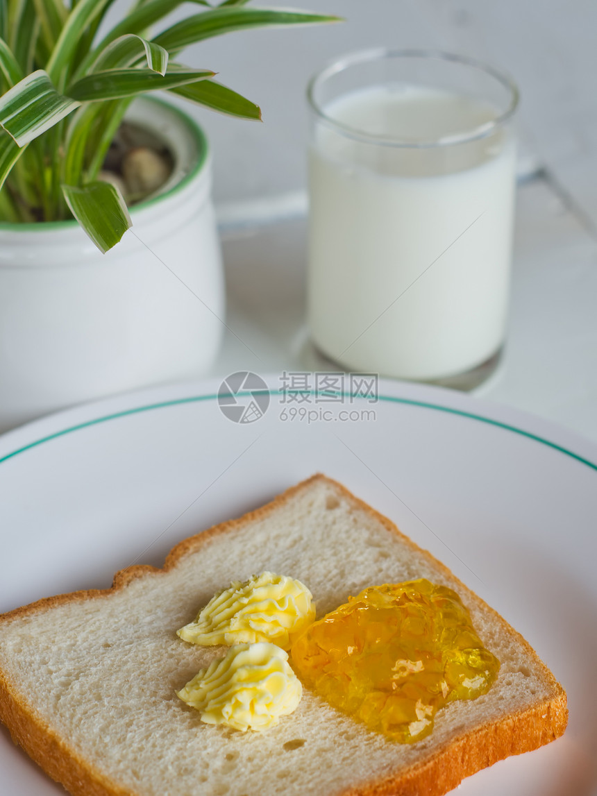 白盘上的面包黄油果酱玻璃甜点食物牛奶白色盘子早餐小吃黄油饮食图片